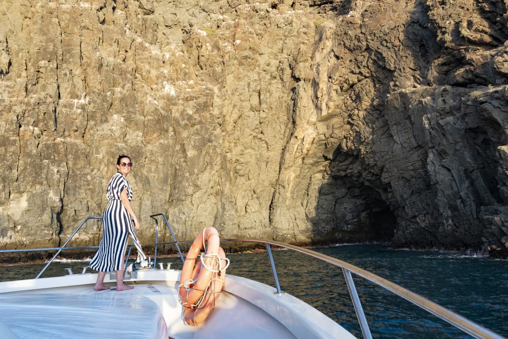 Mujer en proa de barco con vistas a acantilado de los gigantes tenerife